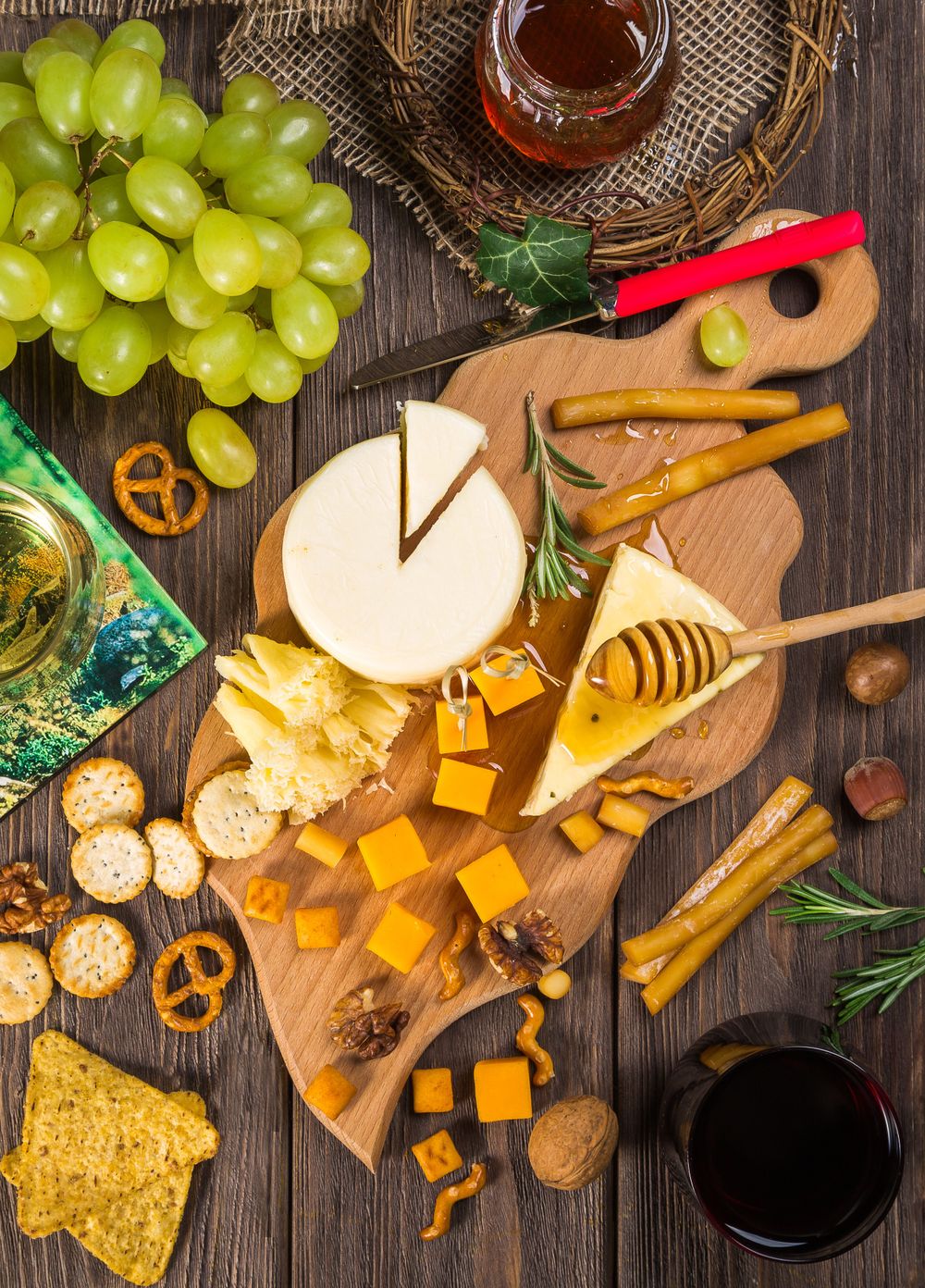 A cheese board with grapes, crackers and assorted cheeses
